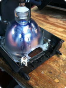 Counterfeit DLP projection TV lamp with cut cooling vent in reflector housing